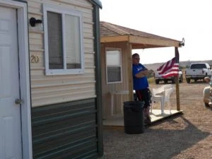 Guest hanging an American flag on a cabin porch